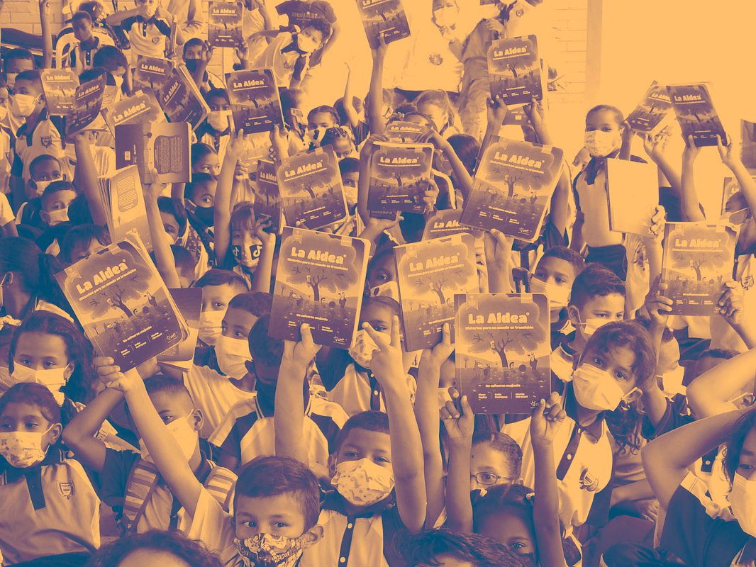 Imagen niños levantando libros de la aldea